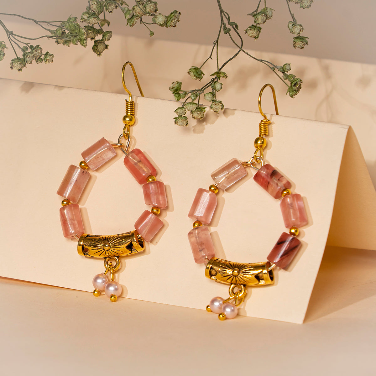 Eykaa cherry quartz with golden charms and shell pearls semi precious stone earrings on a creme background