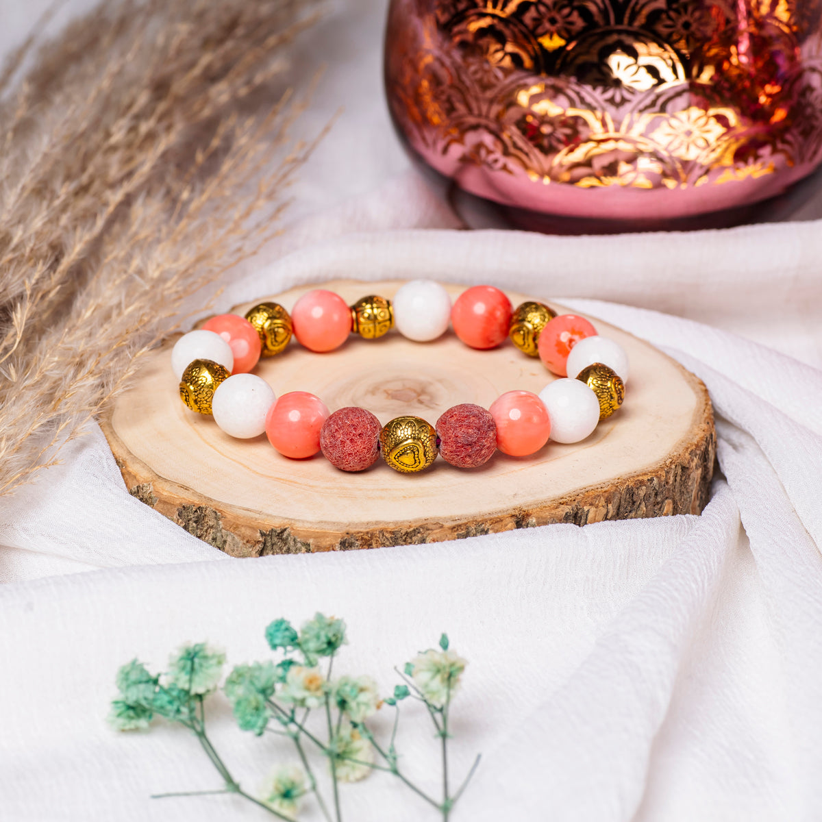Eykaa Marble, Coral And Bamboo Coral With Golden Beads Bracelet On A Rustic Wooden Slice.