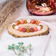 Eykaa Marble, Coral And Bamboo Coral With Golden Beads Bracelet On A Rustic Wooden Slice.