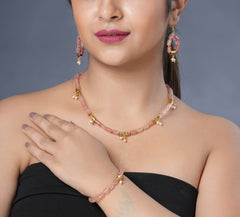 Girl model wearing Eykaa cherry quartz, golden charms and shell pearls semi precious stone earrings, necklace and bracelet.