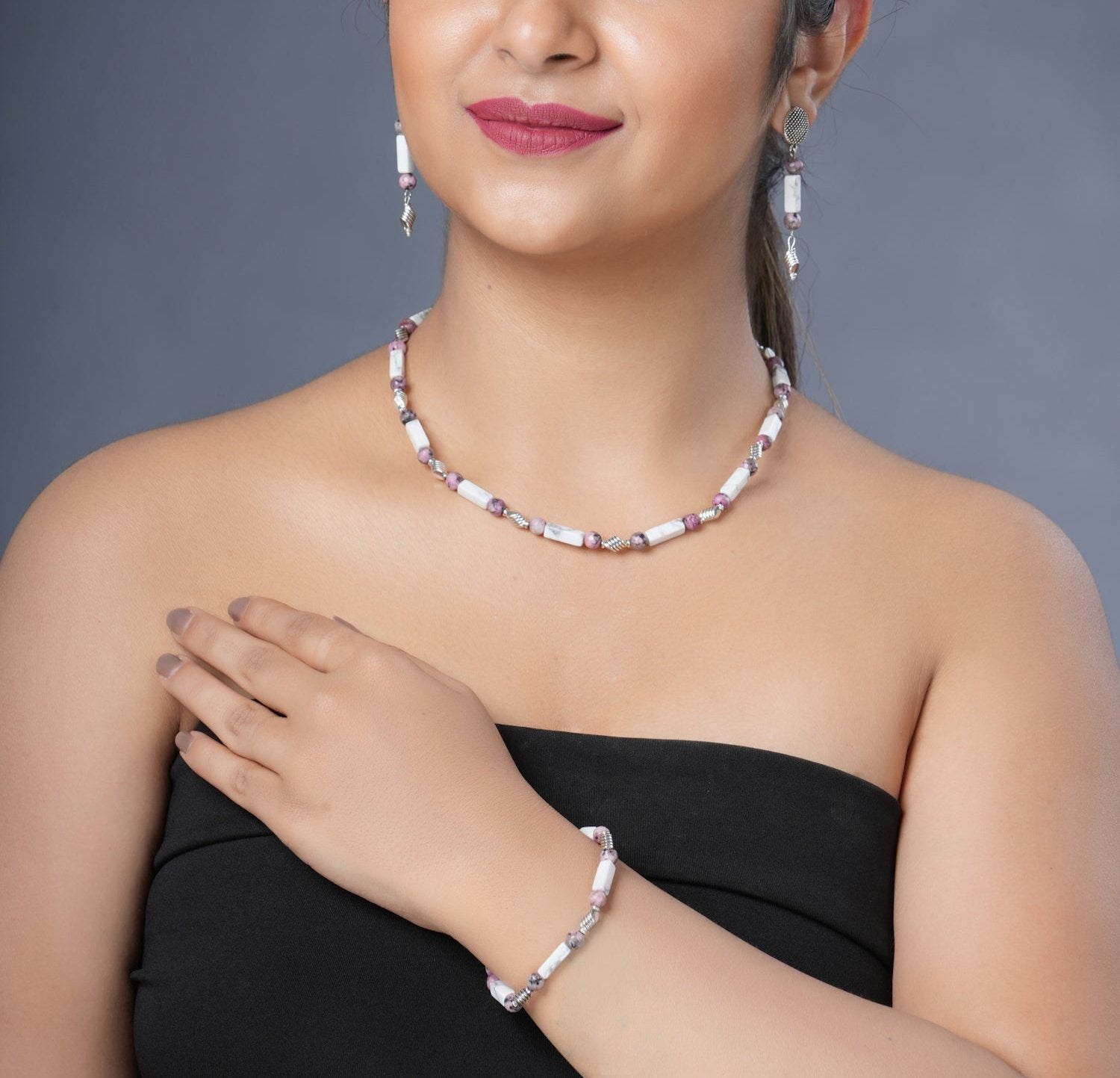 Girl model wearing Eykaa white howlite with dalmatian and silver charms semi precious stone necklace, earrings and bracelet