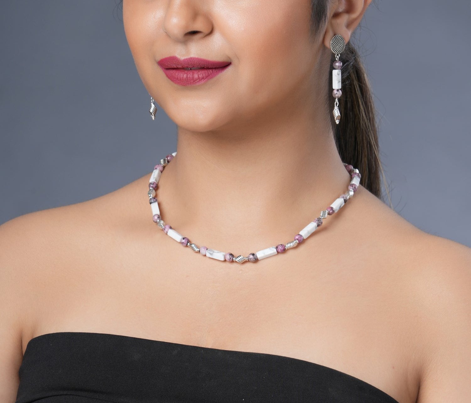 Girl model wearing Eykaa white howlite with dalmatian and silver charms semi precious stone necklace and earrings