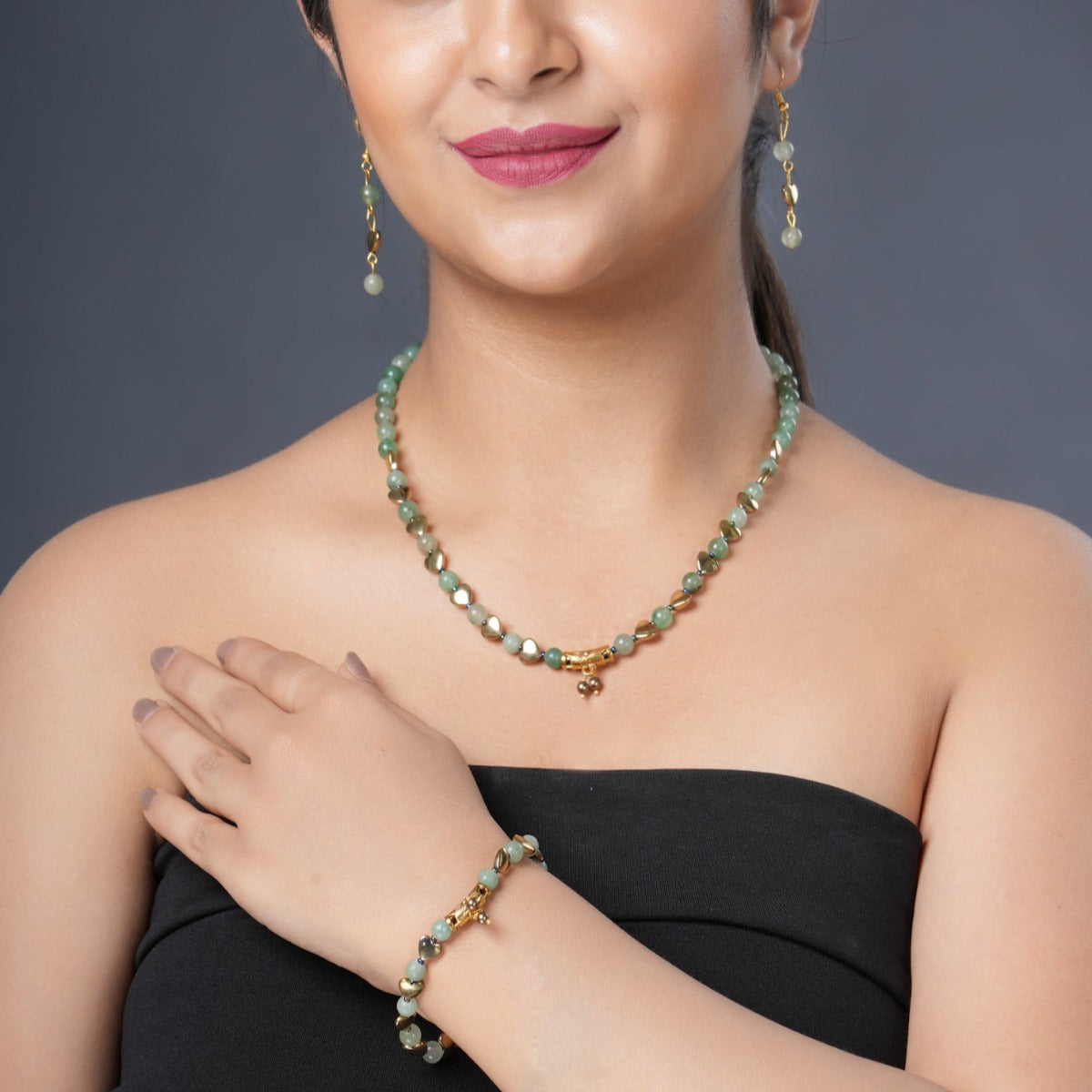 Girl model wearing Eykaa green aventurine, golden hematite and shell pearl semi precious stone necklace, earring and bracelet