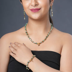 Girl model wearing Eykaa green aventurine, golden hematite and shell pearl semi precious stone necklace, earring and bracelet