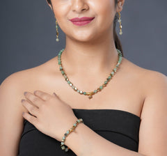Girl model wearing Eykaa green aventurine, golden hematite and shell pearl semi precious stone necklace, earring and bracelet