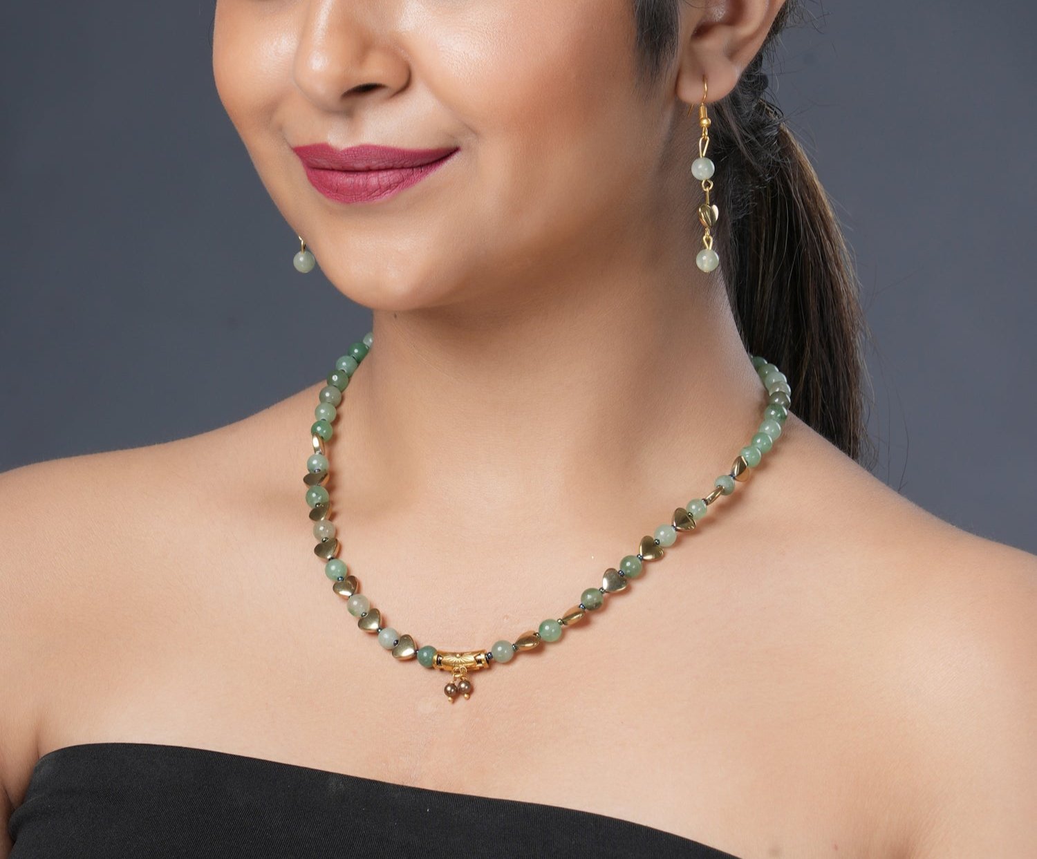 Girl model wearing Eykaa green aventurine, golden hematite and shell pearls semi precious stone necklace and earrings