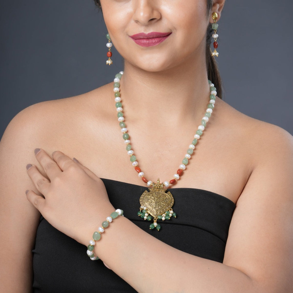 Girl Model Wearing Eykaa Green Aventurine, Golden Hematite With Golden Charms And Shell Pearls Necklace With Earrings And A Bracelet.