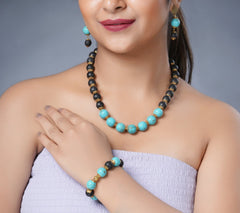 Girl Model Wearing Eykaa Firoza And Lava With Golden Charms Necklace With Earrings And A Bracelet.