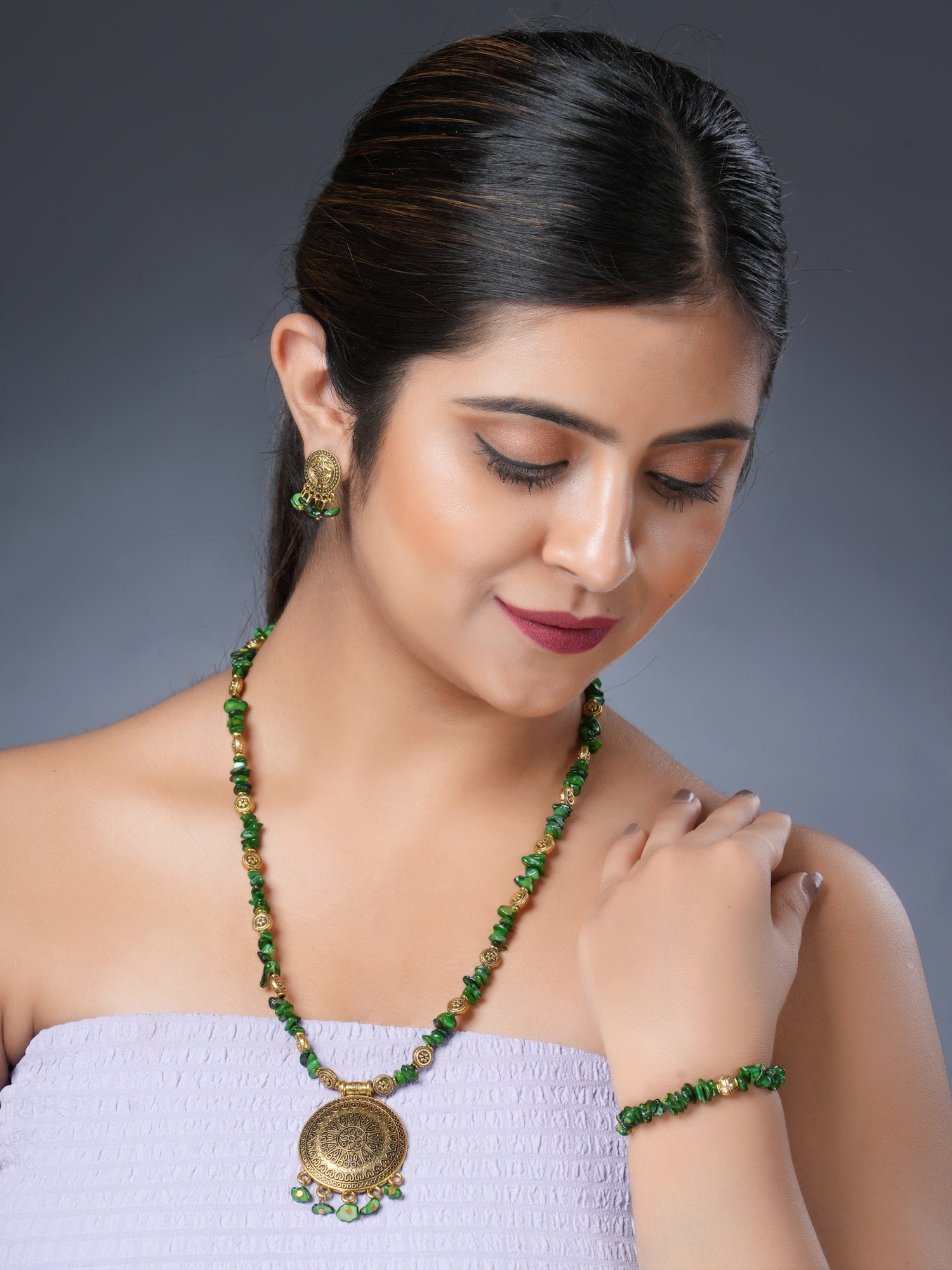 Girl model wearing Eykaa necklace, earrings and bracelet that features EYKAA GREEN MOTHER OF PEARL WITH GOLDEN CHARMS AND PENDANT BRACELET | I-B-919020