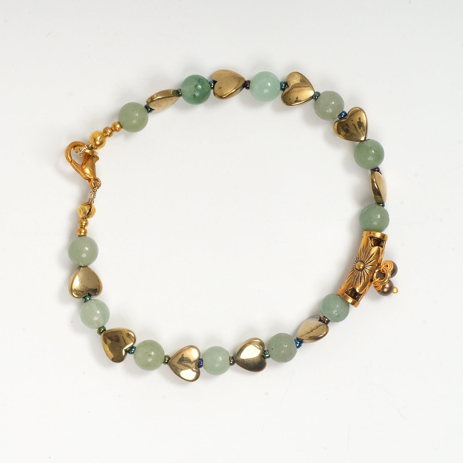 Eykaa green aventurine, golden hematite with golden charms and shell pearls semi precious stone bracelet on white background.