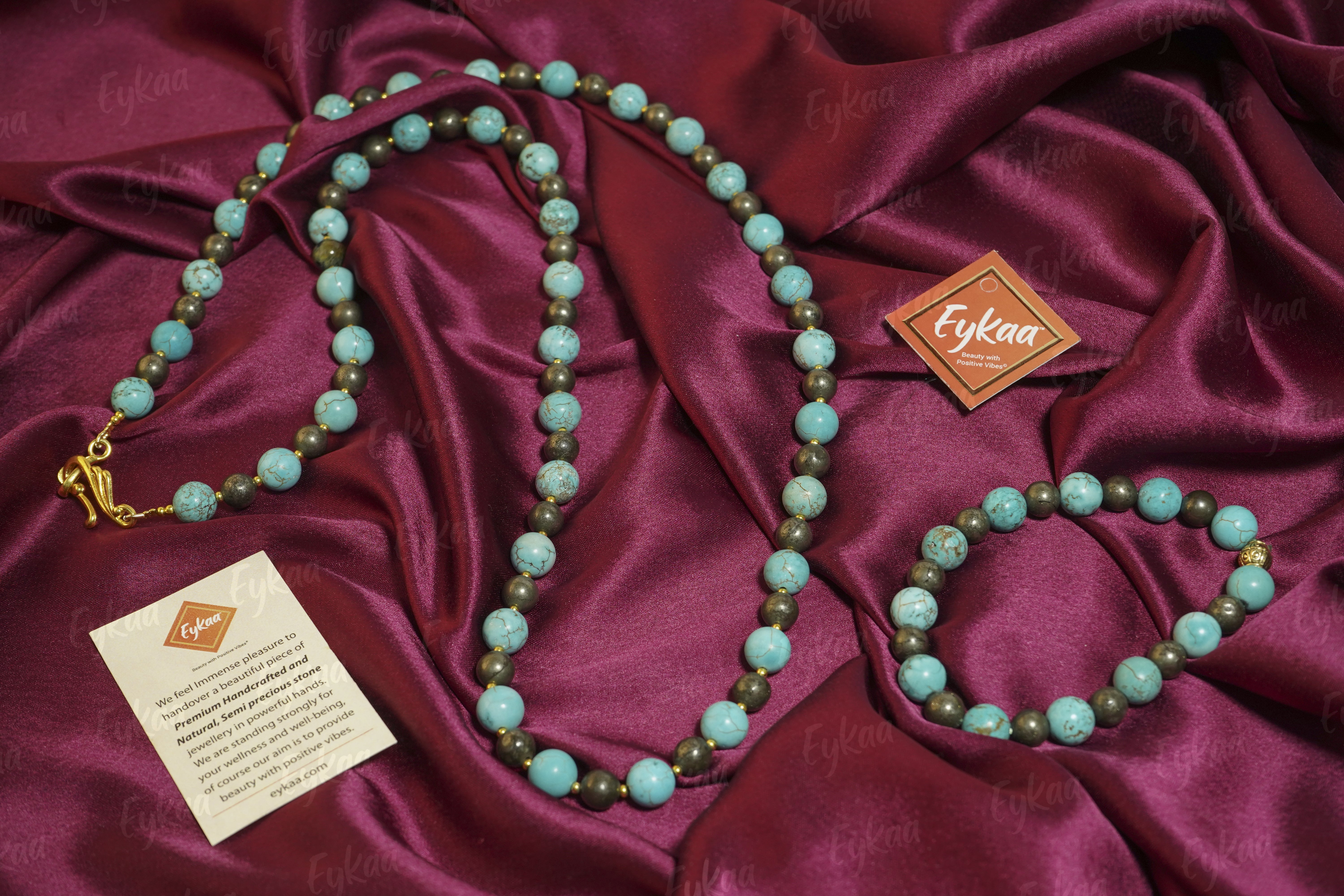 Eykaa EYKAA FIROZA WITH PYRITE AND GOLDEN BEADS BRACELET beside red velvet box, silky pink fabric, and orange flowers