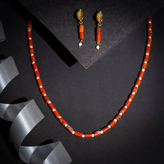 Eykaa brand red jasper with shell pearls semi precious stone earrings and a necklace on black background with silver lace.