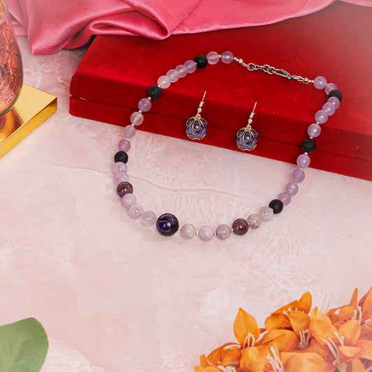 Eykaa jade, kunzite and amethyst semi precious stone jewelry set beside red velvet box, silky pink fabric, and orange flower