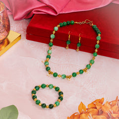 Eykaa EYKAA GREEN JADE WITH SHELL PEARLS WITH GOLDEN BEADS BRACELET beside red velvet box, silky pink fabric, and orange flowers