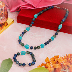 Azurite and firoza semi precious stone Eykaa necklace and bracelet beside red velvet box, silky pink cloth and orange flowers