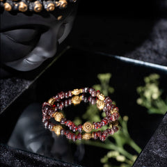 EYKAA GARNET WITH GOLDEN CHARMS AND GOLDEN PENDANT BRACELET with black background beside silver lace.