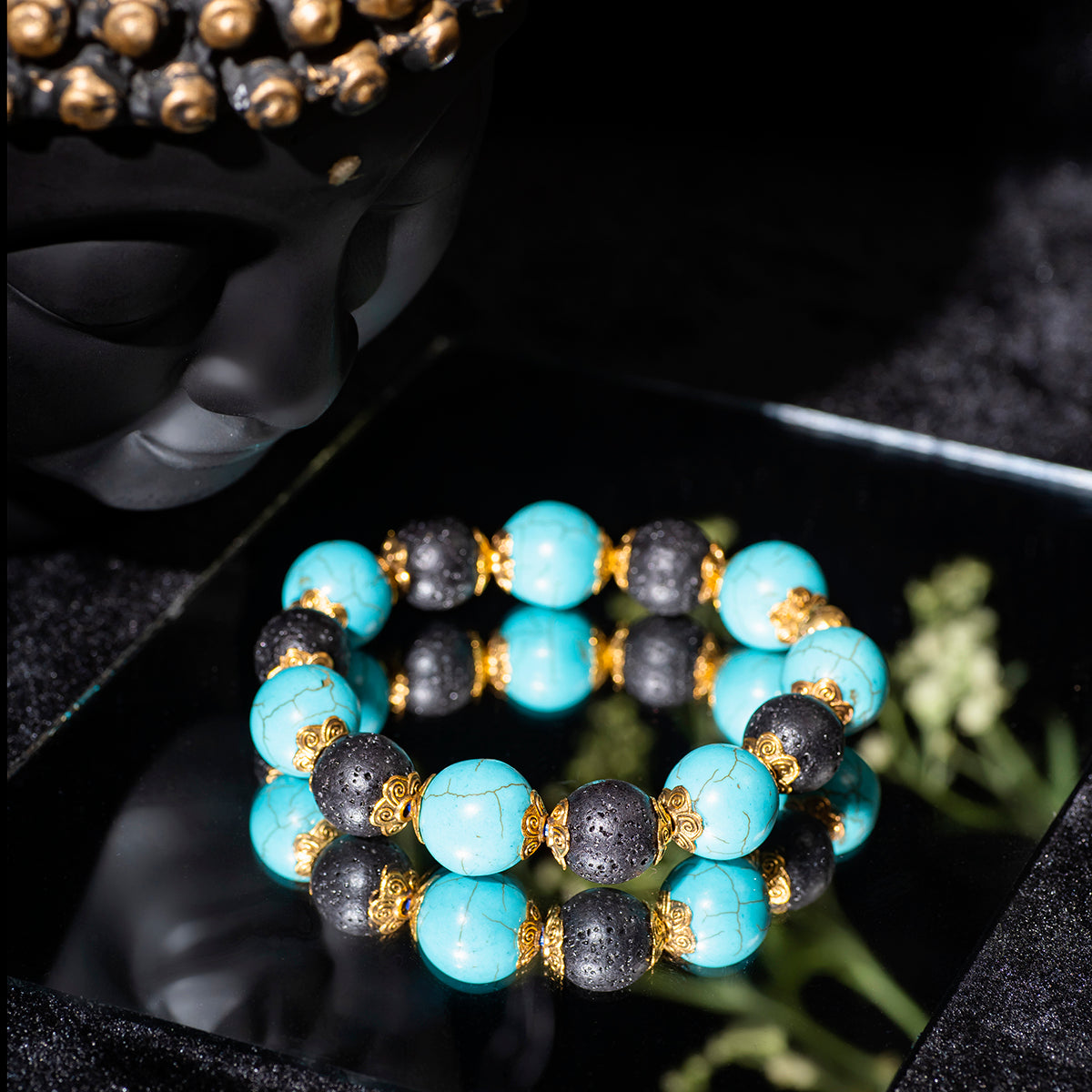 EykaaEYKAA FIROZA AND LAVA WITH GOLDEN CHARMS 12 MM AND 14 MM BRACELET black background beside silver lace.