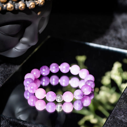 Eykaa EYKAA PURPLE JADE BRACELETwith black background beside silver lace.