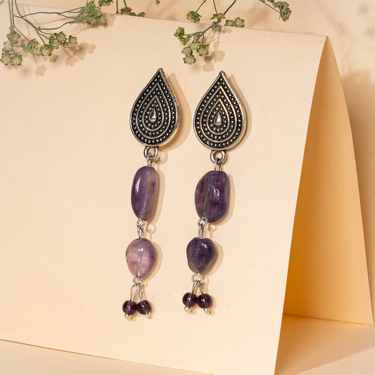 Eykaa EYKAA AMETHYST TUMBLE LAYERED EARRINGS over cream coloured calender folder with cream background