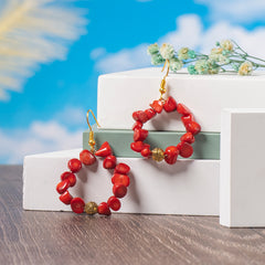 Eykaa White And Red Coral With Golden Beads Earrings Displayed On Multi-tiered Platform With Sky And Clouds Background.