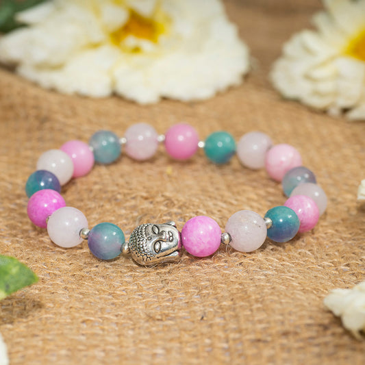 Eykaa pink and multicolored jade layered semi precious stone bracelet with silver charms on sack surface with white flowers.