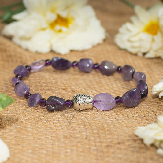 Eykaa amethyst tumble layered semi precious stone bracelet on a sack surface with beautiful white flowers beside. 