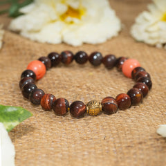 Eykaa red tiger eye with coral semi precious stone bracelet on sack surface with white flowers.