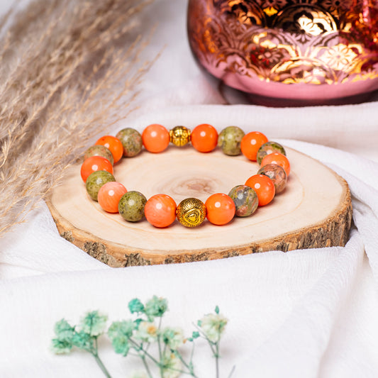 Eykaa Coral and Unakite with Golden Beads Bracelet On A Rustic Wooden Slice.