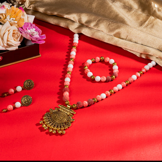 Eykaa Marble, Coral And Bamboo Coral Necklace With Golden Beads Pendant And Earrings With Bracelet On A Vibrant Red Surface.