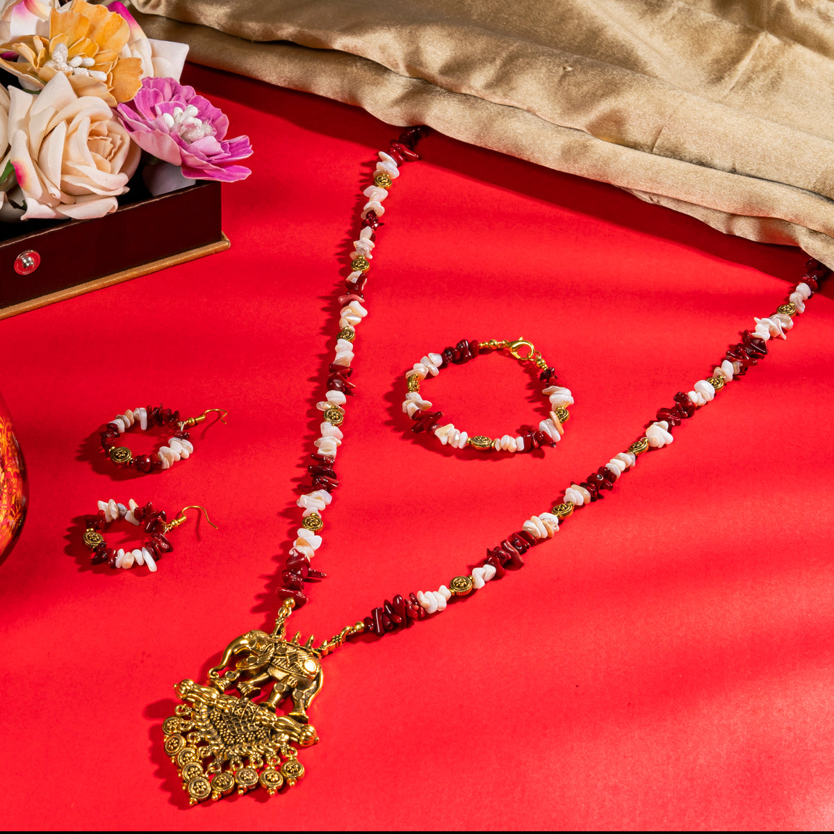 Eykaa White Mother Of Pearl And Coral Necklace With Earrings And Bracelet On A Vibrant Red Surface.