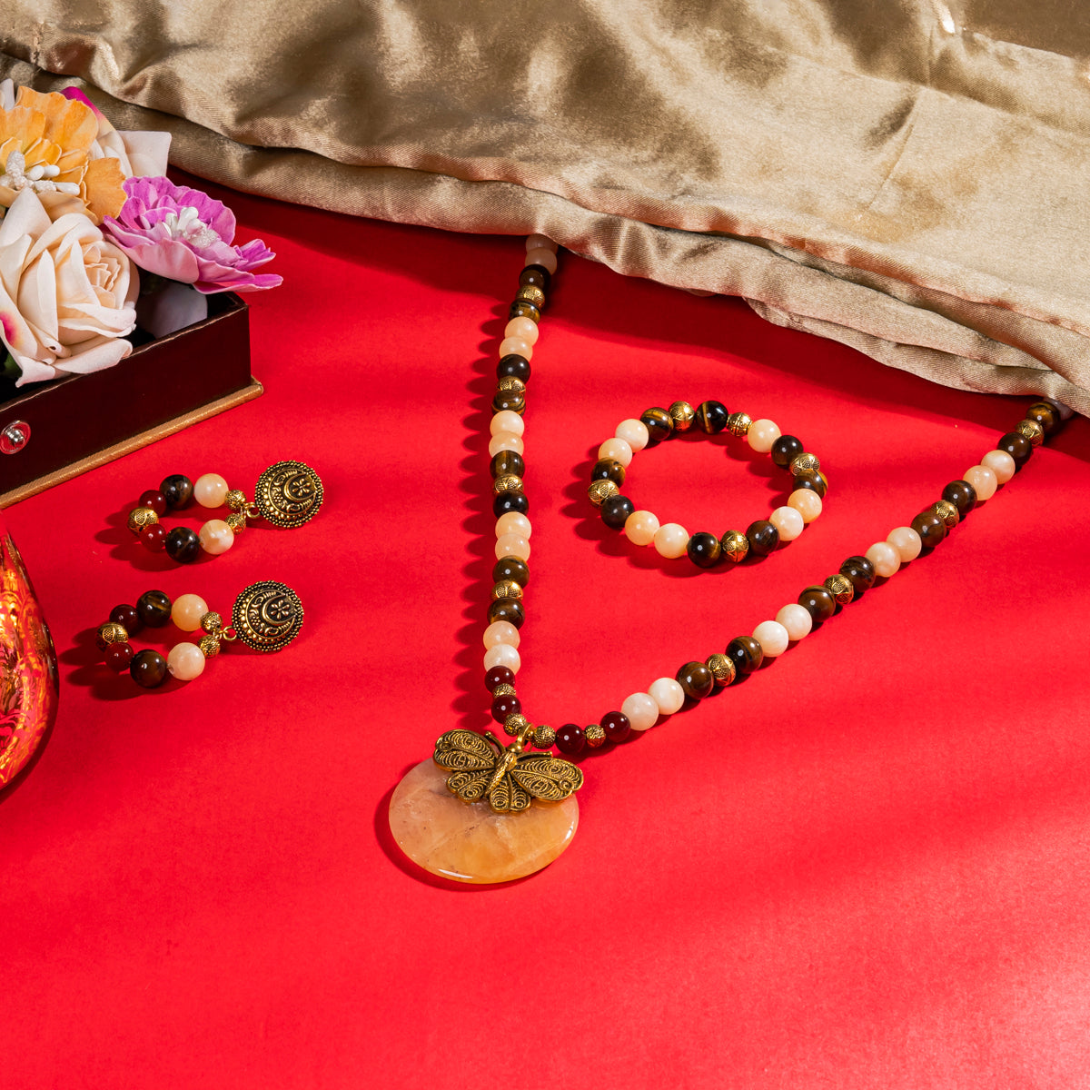 Eykaa Tiger Eye, Yellow Calcite, Red Onyx Necklace With Yellow Aventurine Pendant, Earrings And Bracelet On A  Red Surface.