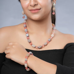 Girl model wearing Eykaa necklace, earrings and bracelet that have cherry quartz, agate and black onyx semi precious stones