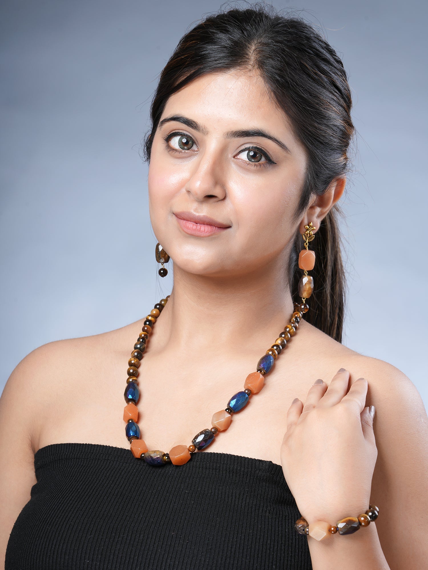 Girl model wearing Eykaa necklace, earrings and bracelet that have semi precious stone tiger eye, hematite with carnelian.Eykaa TIGER EYE AND HEMATITE WITH CARNELIAN NECKLACE