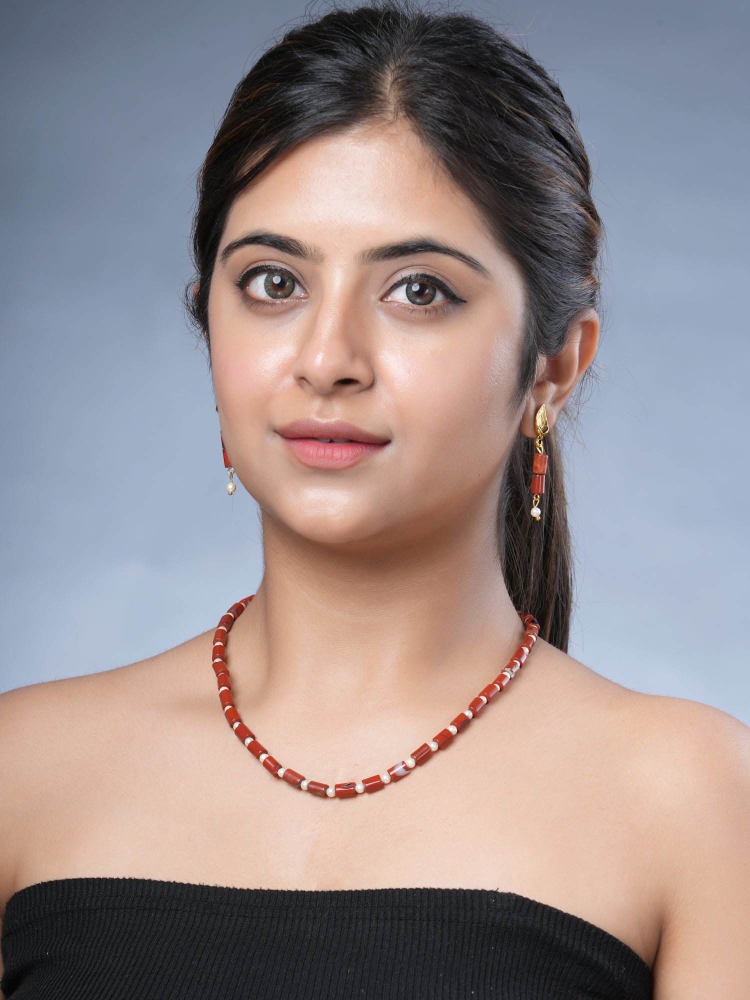 Girl model wearing Eykaa brand red jasper with shell pearls semi precious stone necklace and earrings. 