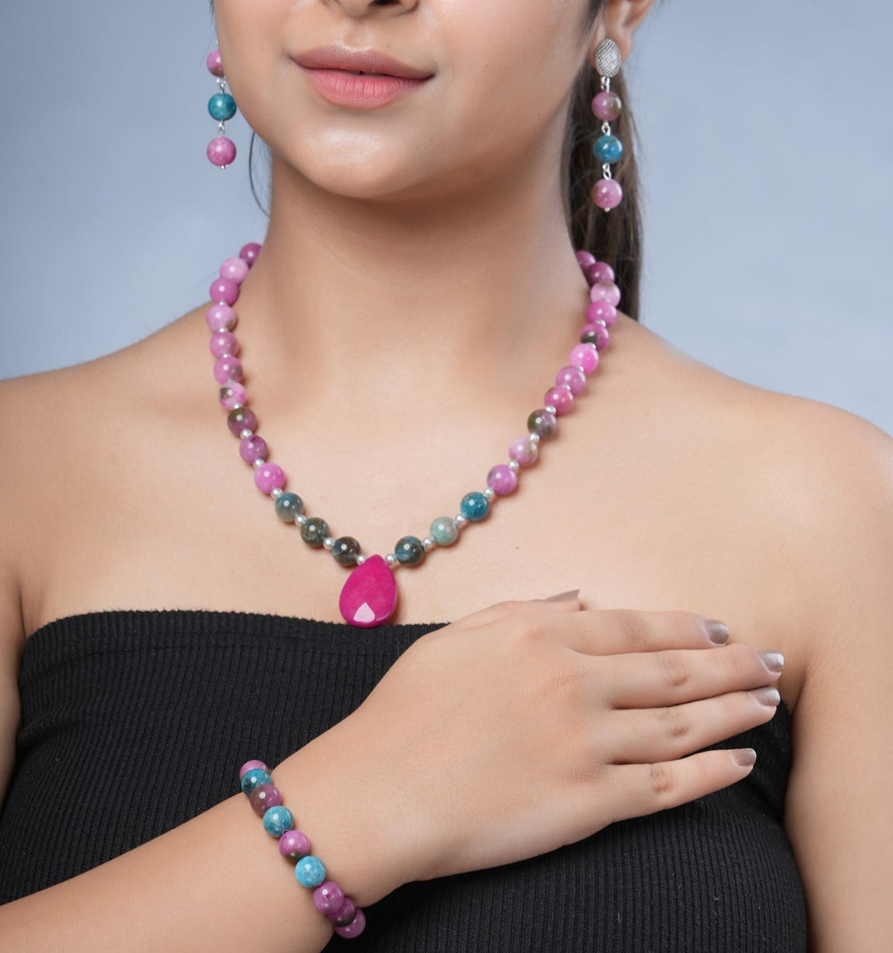 Girl model wearing Eykaa necklace and earrings that features semi precious stone  EYKAA PINK JADE BLUE APATITE WITH PINK AGATE AND SHELL PEARLS BRACELET