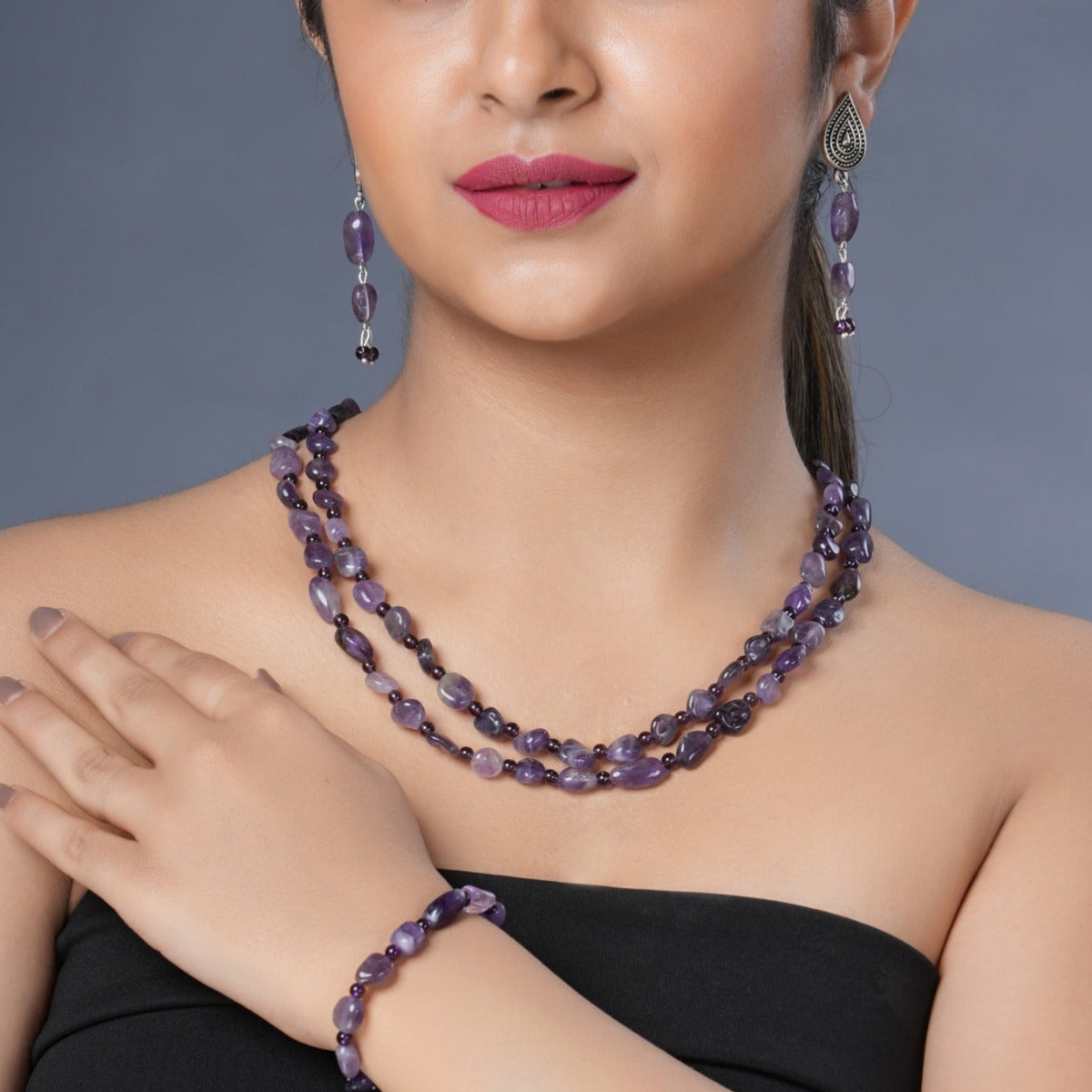  Girl model wearing Eykaa necklace, earrings and bracelet that feature amethyst semi precious stone.    