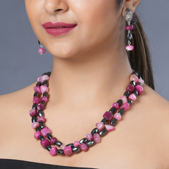 Girl model wearing Eykaa necklace and earrings that feature pink agate and hematite semi precious stones.