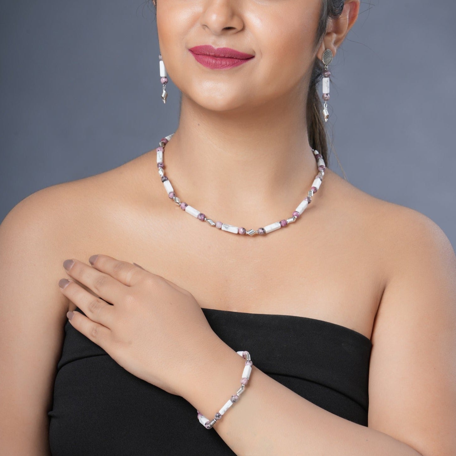 Girl model wearing Eykaa white howlite with dalmatian and silver charms semi precious stone necklace, earrings and bracelet