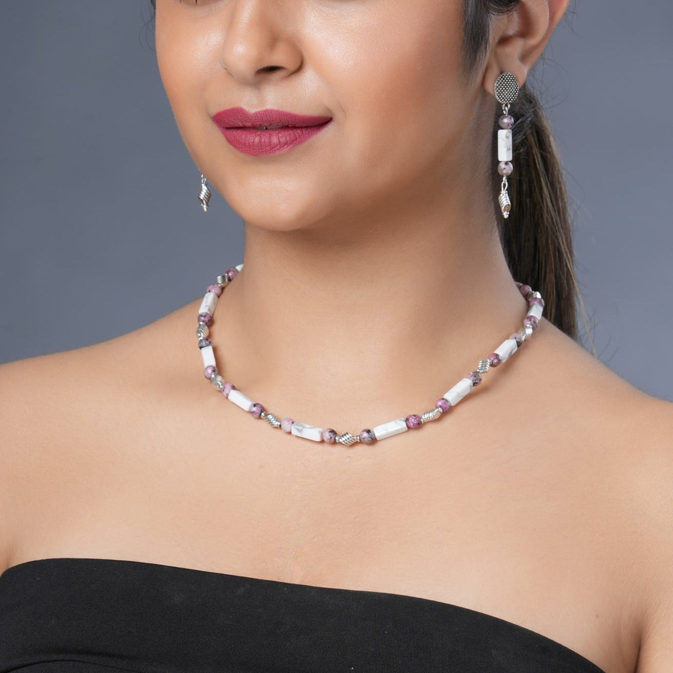 Girl model wearing Eykaa white howlite with dalmatian and silver charms semi precious stone necklace and earrings