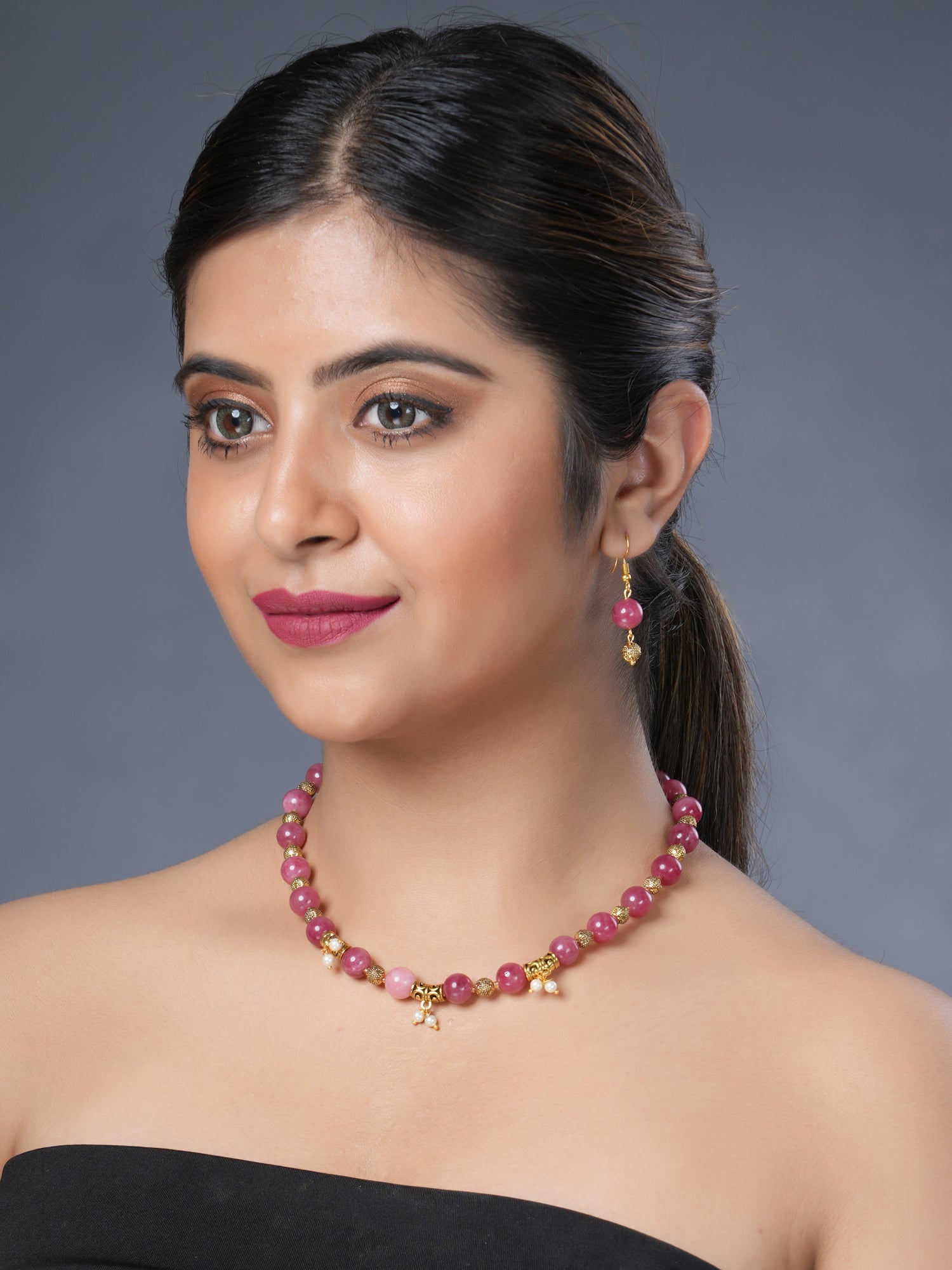 Girl model wearing Eykaa necklace and earrings  that features pink jade and shell pearl semi precious stone 