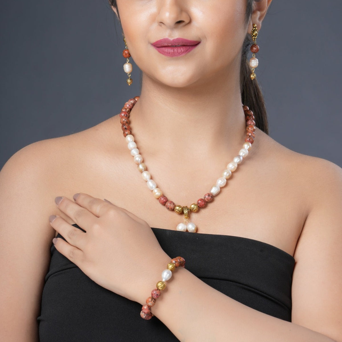 Girl model Wearing Eykaa Orange Dalmatian And Freshwater Pearl Necklace With Earrings And A Bracelet.