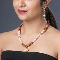 Girl Model Wearing  Eykaa Orange Dalmatian And Freshwater Pearl Necklace With Earrings.