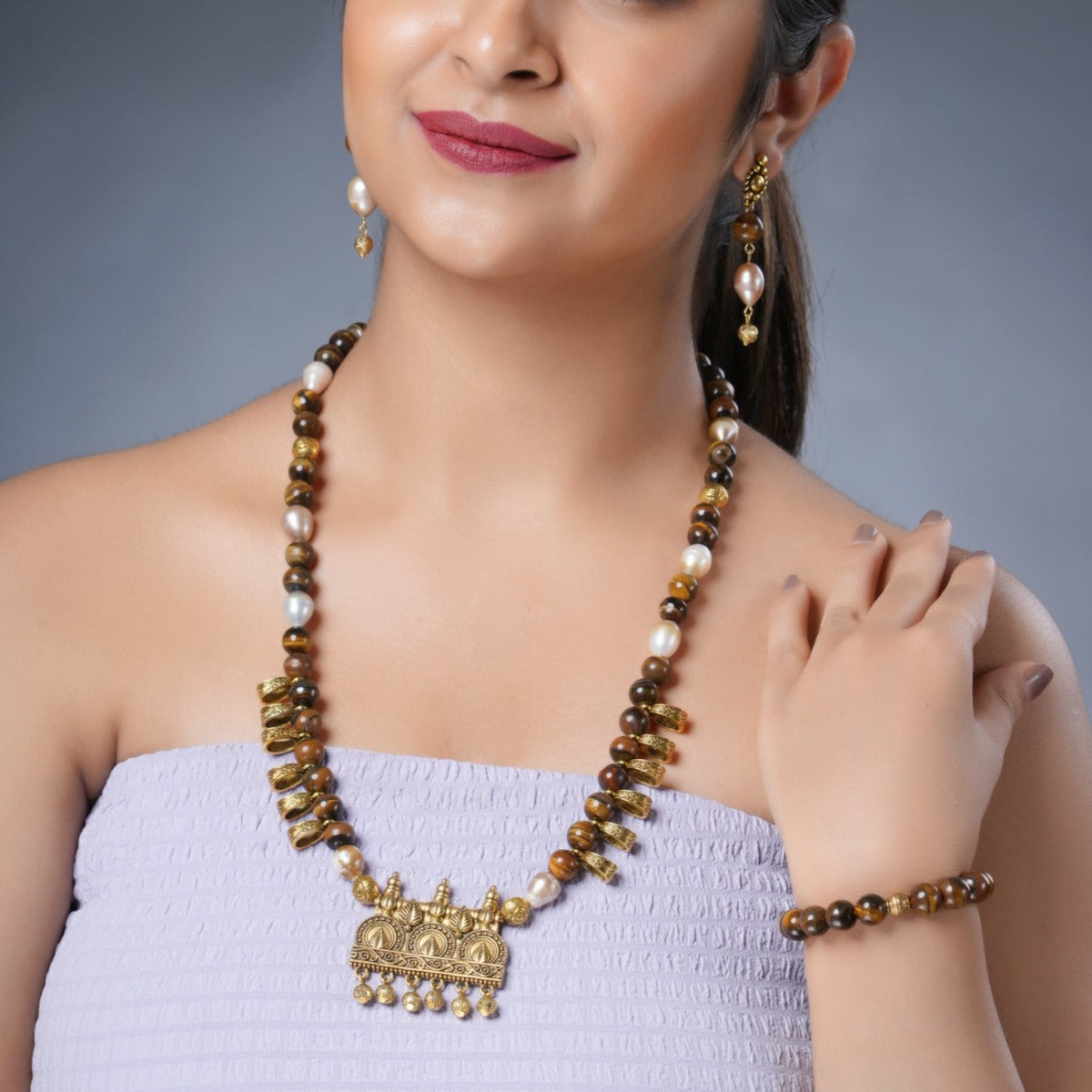 Girl Model Wearing Eykaa Freshwater Pearl And Tiger Eye Necklace With Earrings And A Bracelet.