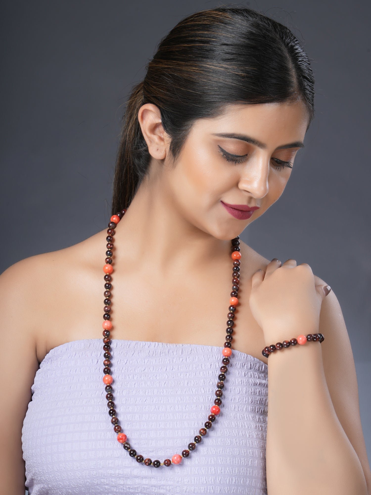 Girl model wearing Eykaa red tiger eye with coral semi precious stone necklace and bracelet