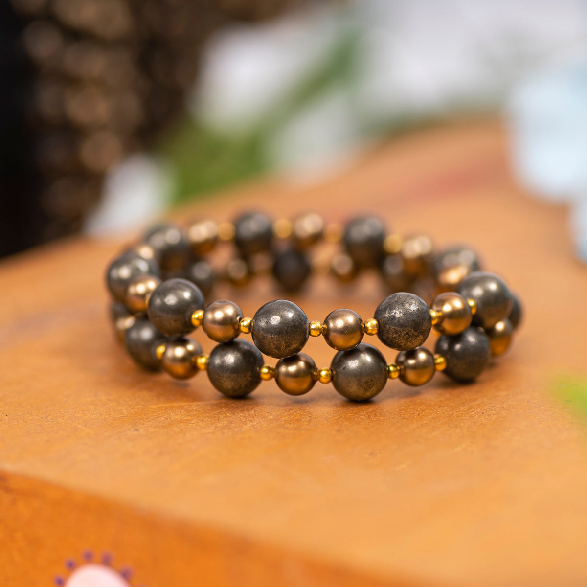  Eykaa Pyrite With Shell Pearls And Shell Bracelet Displayed On A Textured Orange Surface.