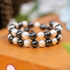 Eykaa Hematite And Freshwater Pearl Bracelet Displayed On A Textured Orange Surface.