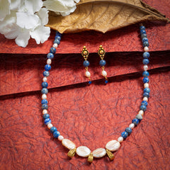 Eykaa Lapis Lazuli, Freshwater Pearl, And Jade Necklace With Earrings On A Textured Red Background With White Flowers.