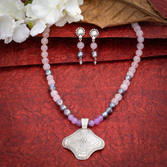 Eykaa Rose Quartz, Jade, And Freshwater Pearl Necklace With Earrings On A Textured Red Background With White Flowers.