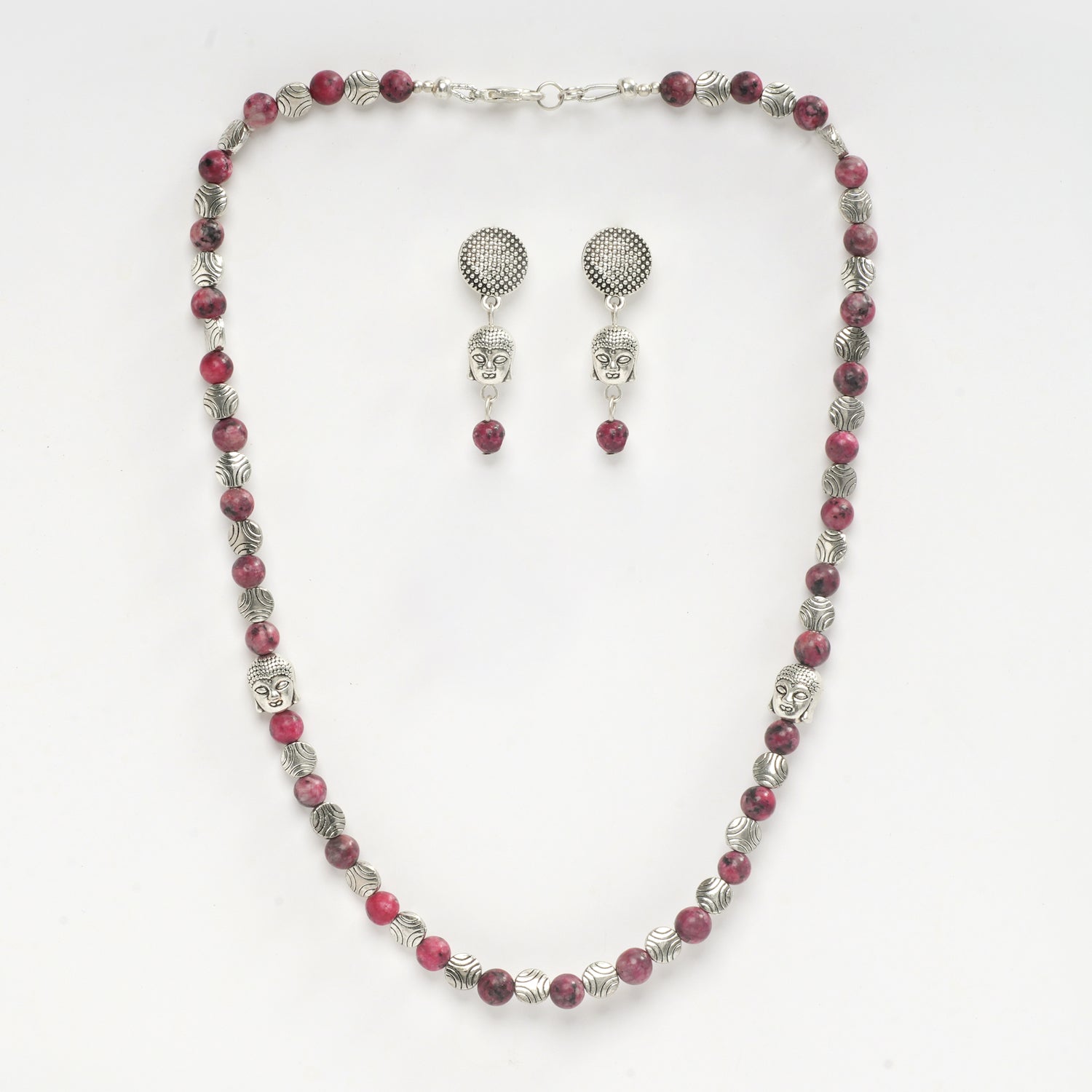 Eykaa Pink Dalmatian With Buddha And Silver Charms Necklace With Earrings On A White Background.