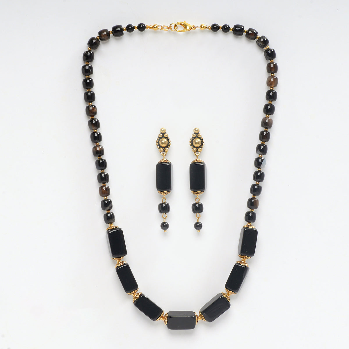 Eykaa brand necklace and earrings that feature semi precious stone black onyx with hakik  on a white background 